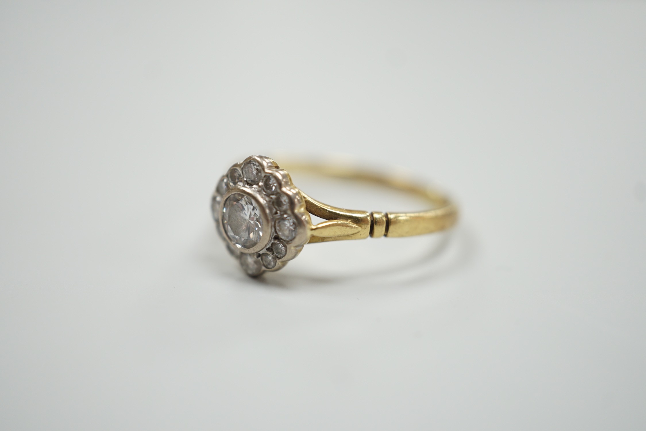 A modern 18ct gold and single stone diamond ring, with diamond set border, size S, gross weight 3.2 grams.